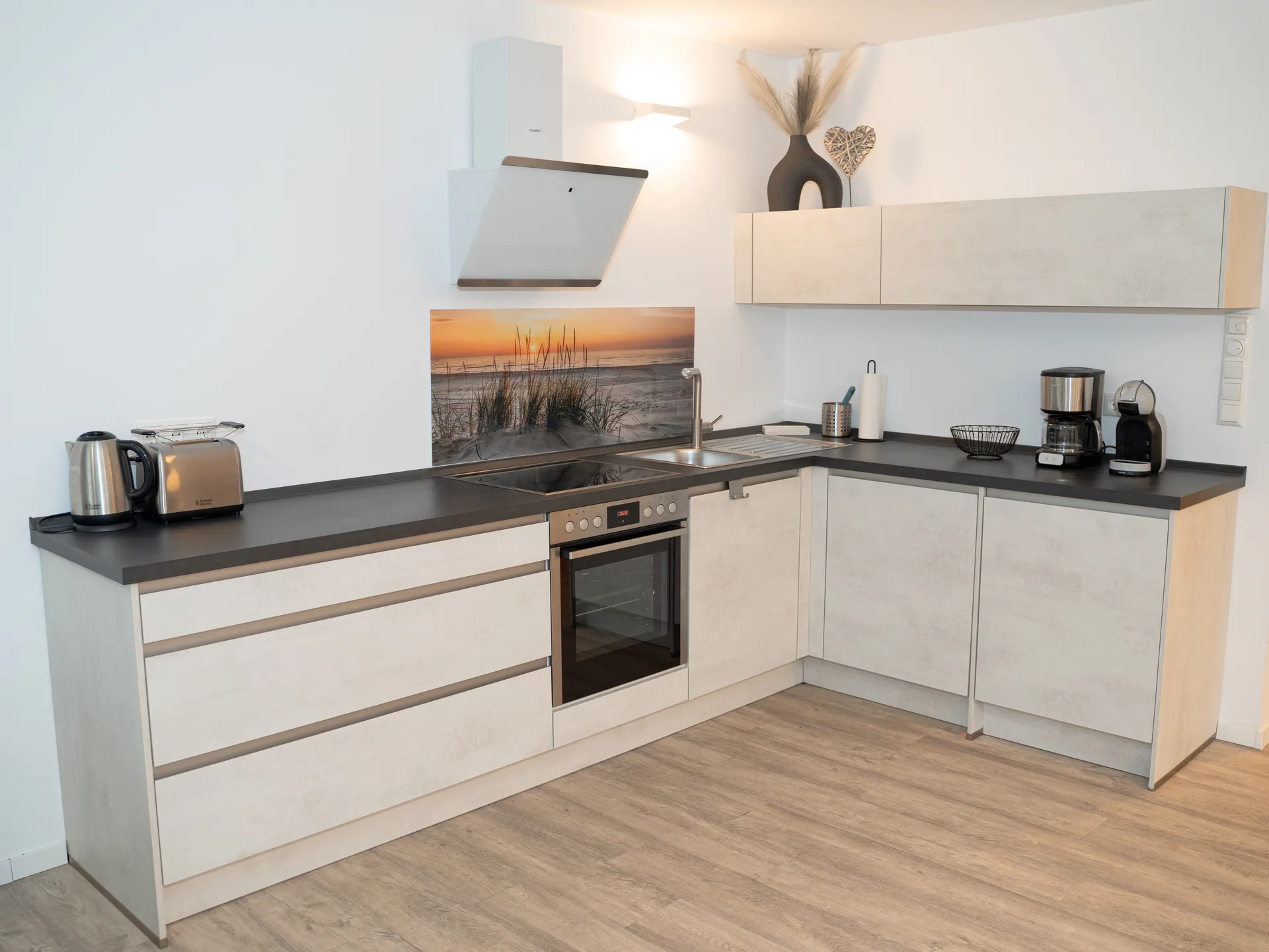 Voll ausgestattete Einbauküche mit Sonnenuntergang-Spritzschutz in der Ferienwohnung Kurparkperle