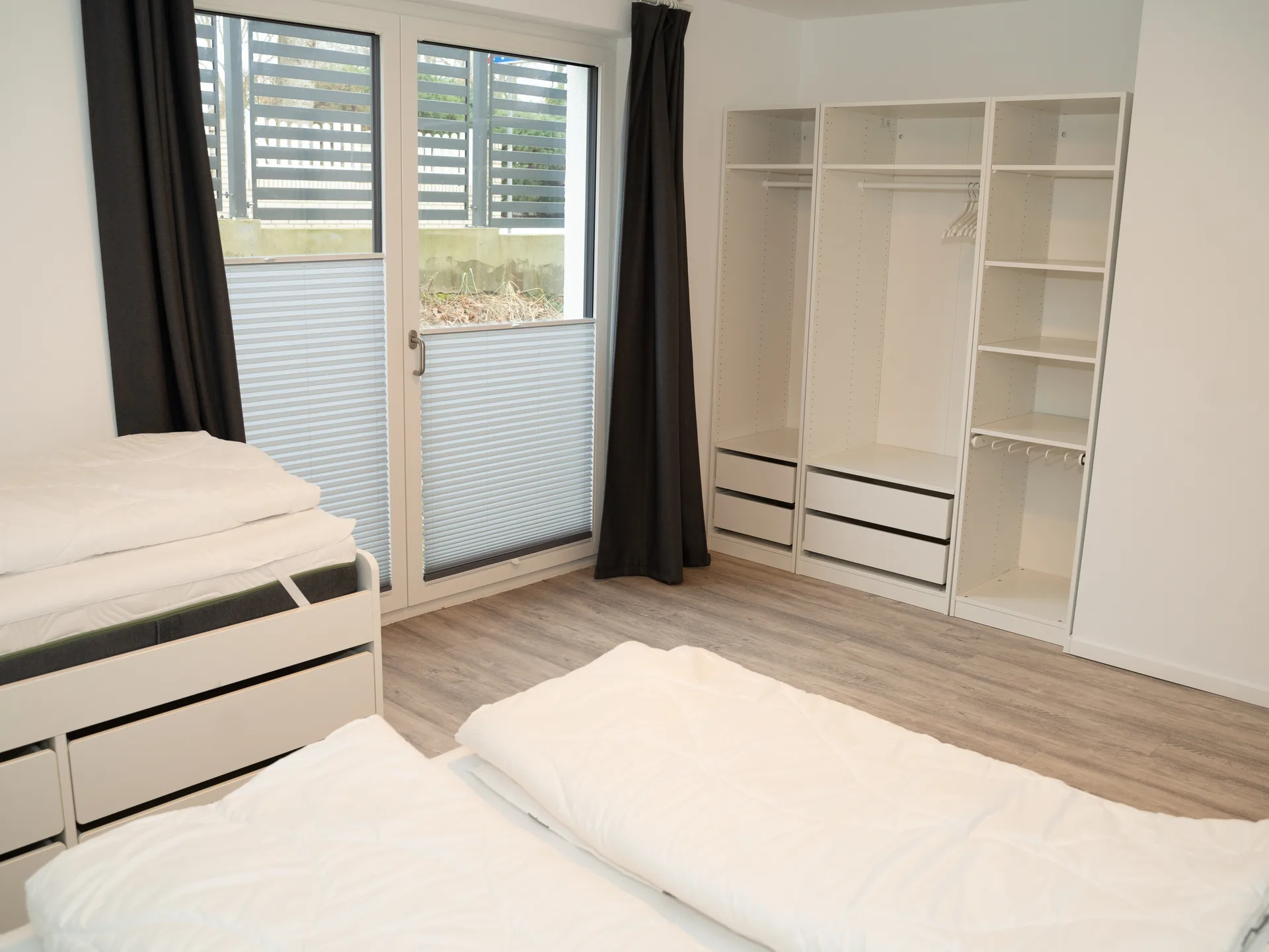 Familienschlafzimmer mit Doppelbett, Einzelbett und TV in der Ferienwohnung Kurparkperle Grömitz