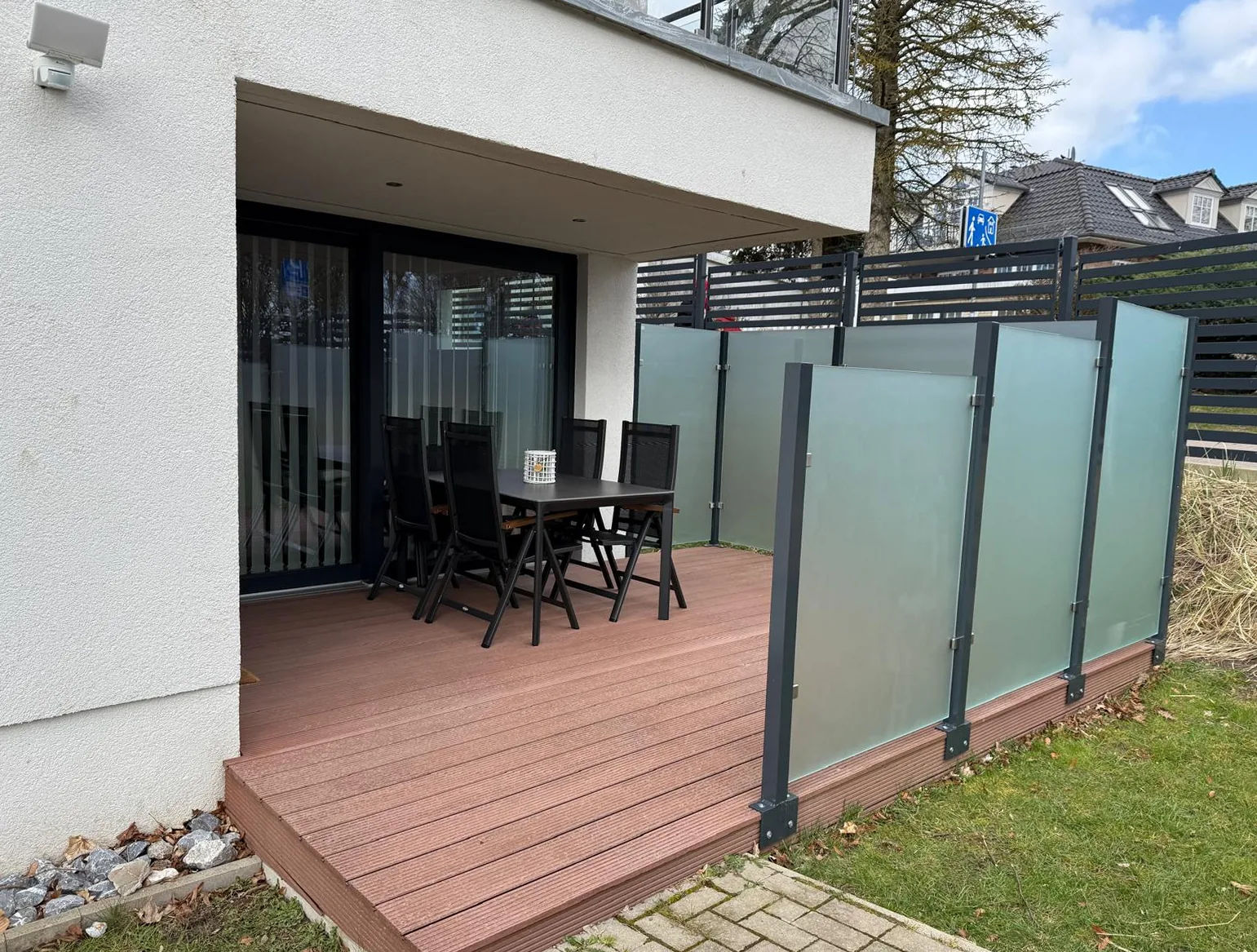 Überdachte Außenterrasse der Ferienwohnung Kurparkperle in Grömitz mit Sitzgruppe und Holzdeck