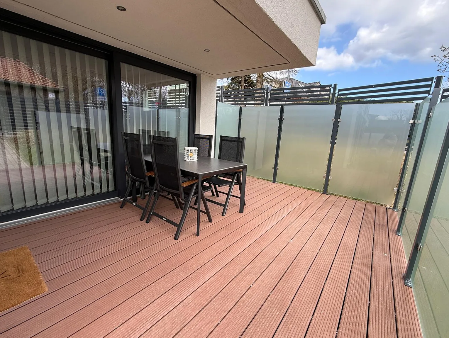 Großzügiges WPC-Holzdeck der Kurparkperle-Terrasse mit Blick vom Wohnbereich in Grömitz